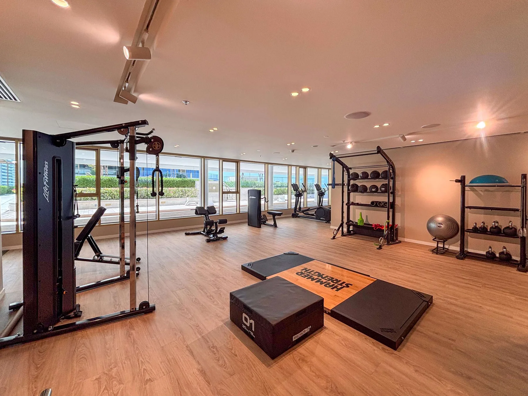 Un gimnasio amplio con máquinas de ejercicio, pesas y espacio abierto.