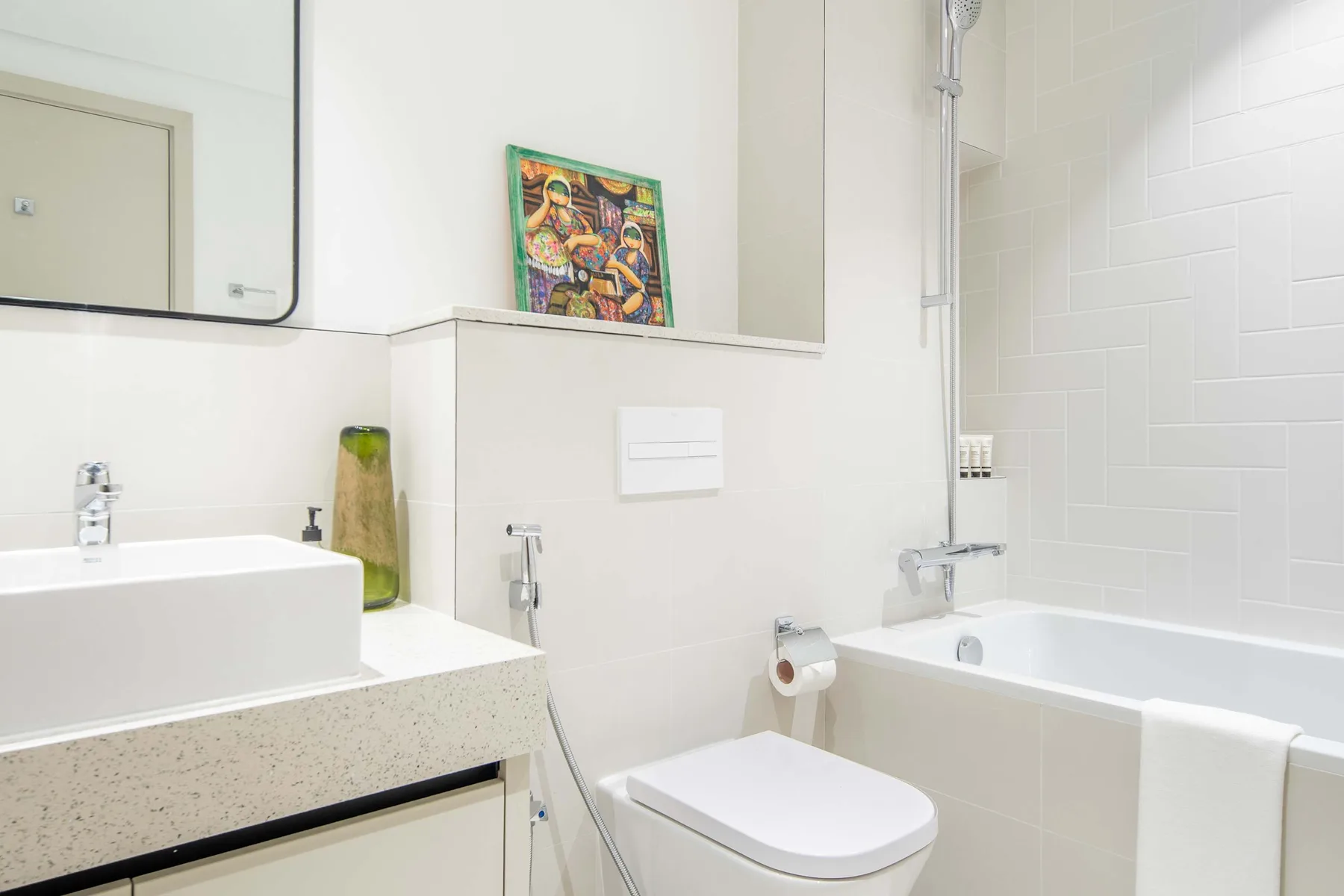 Un baño luminoso con bañera, inodoro y lavabo.