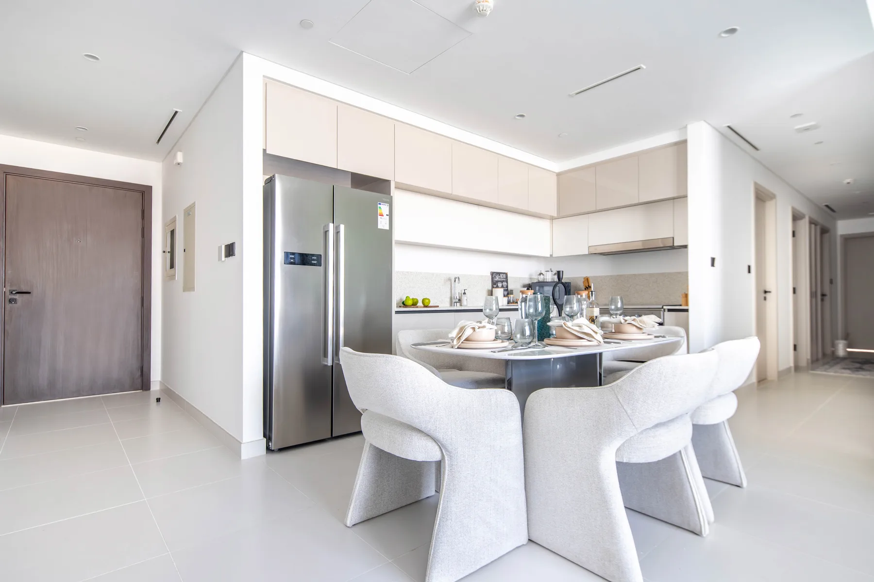 Una cocina luminosa con zona de comedor y una mesa puesta junto a la isla.