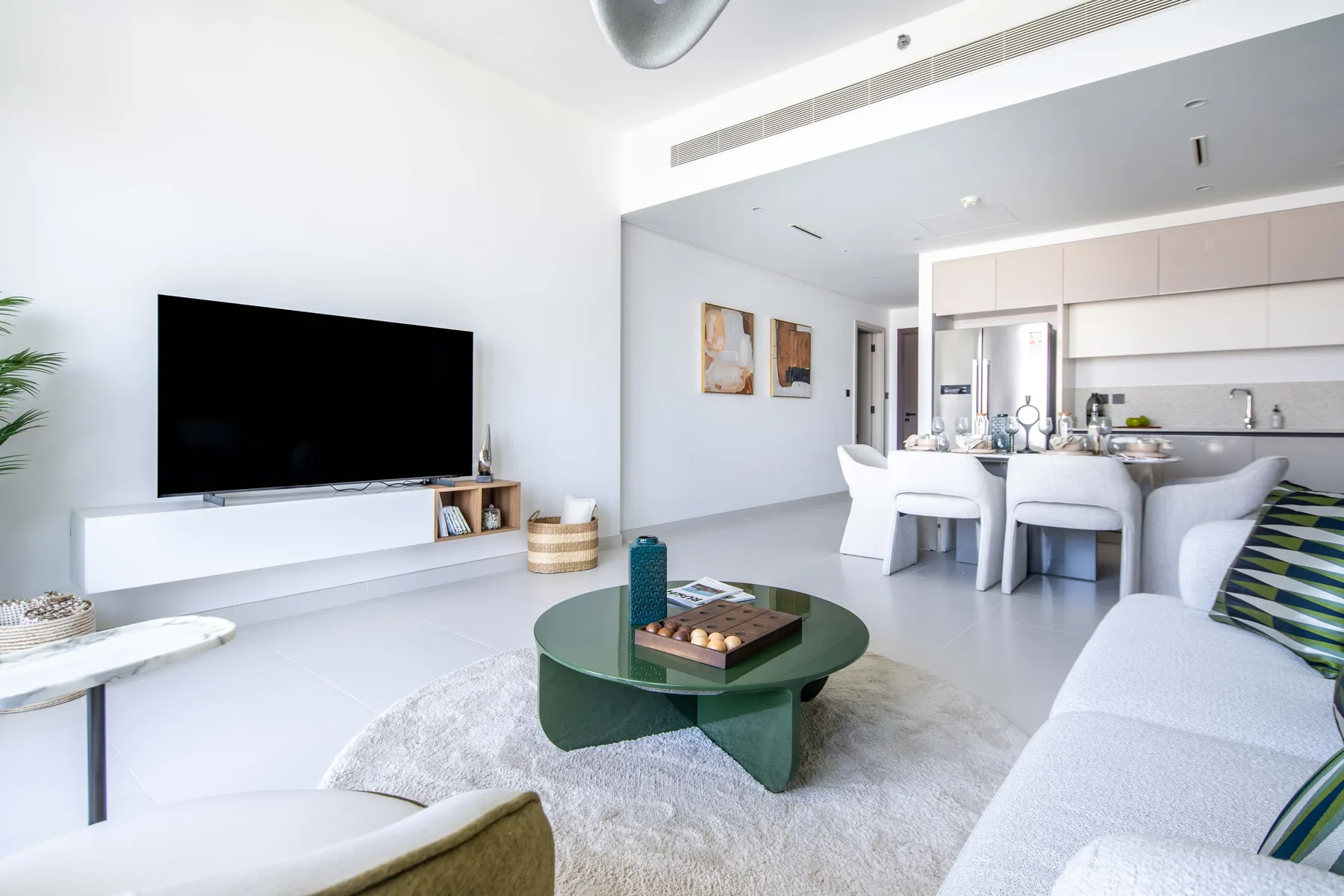 Una sala luminosa se abre a un comedor y una cocina.