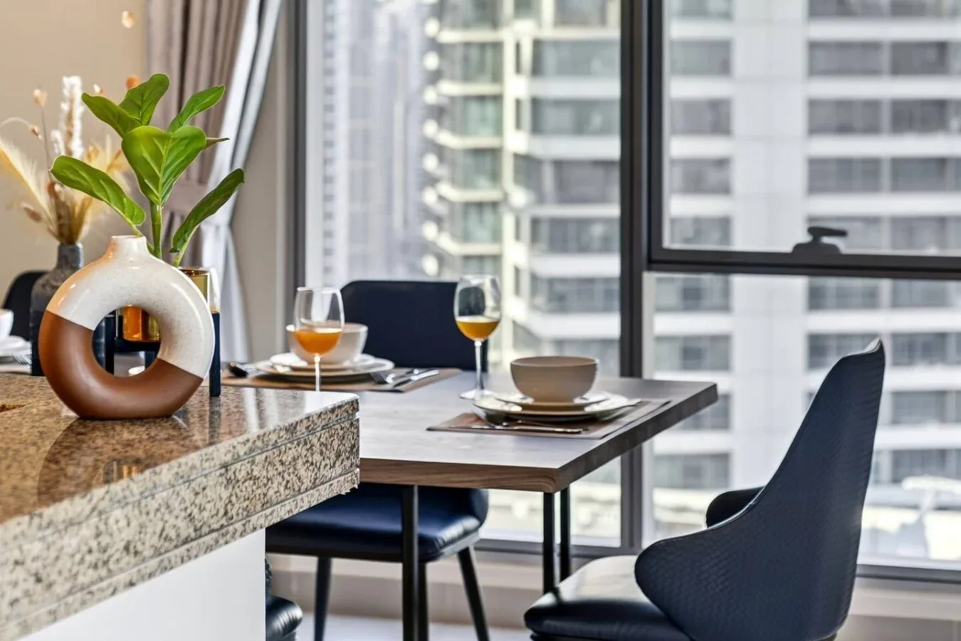 Un comedor con una mesa puesta junto a una ventana grande.
