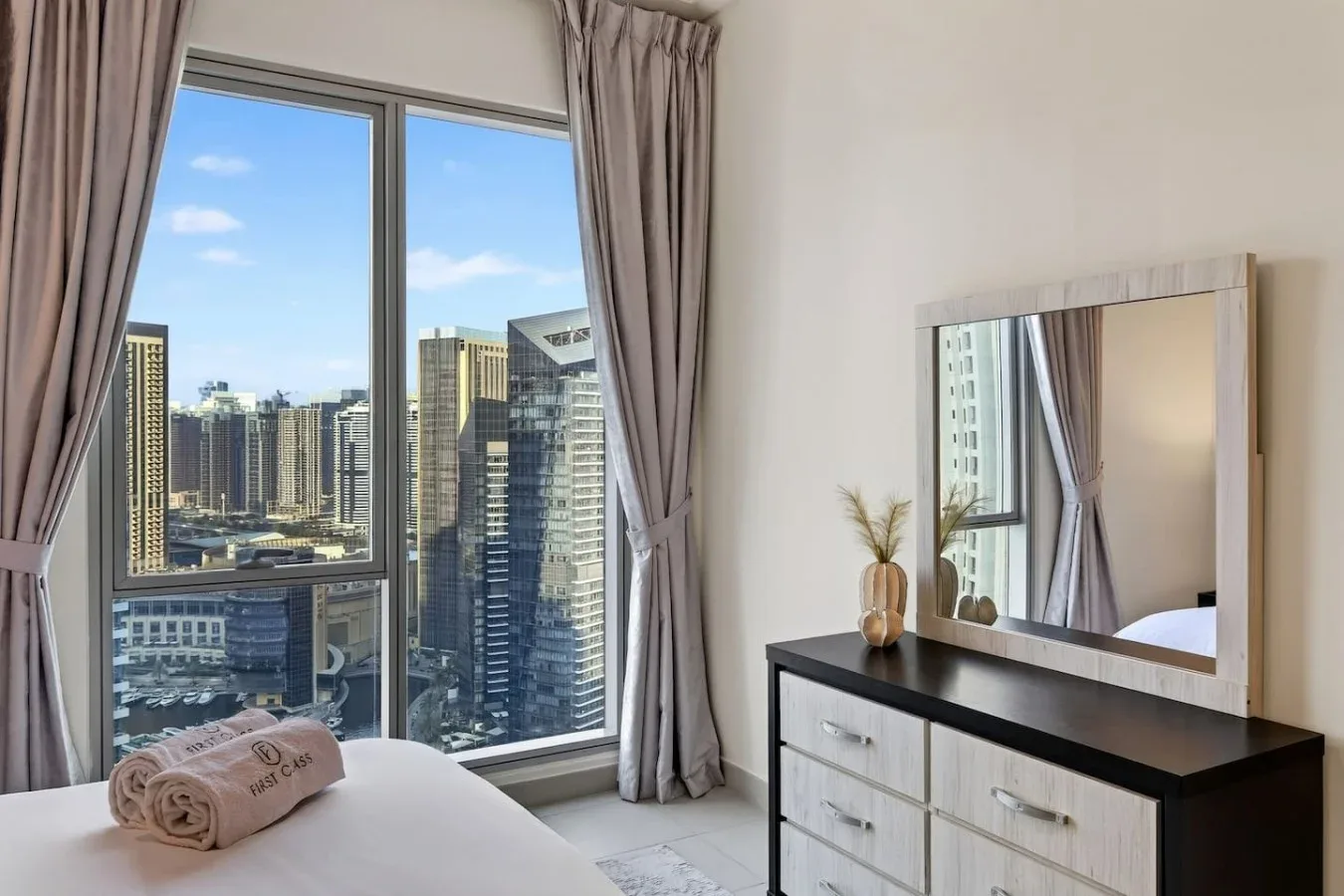 Un dormitorio con una gran ventana frente a edificios de la ciudad.