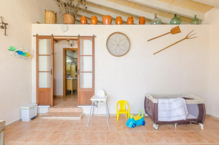 A bright room with a tiled floor, sliding wooden doors, and children’s toys.