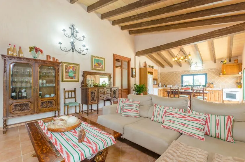 A living room with seating, a wooden coffee table, and exposed ceiling beams.