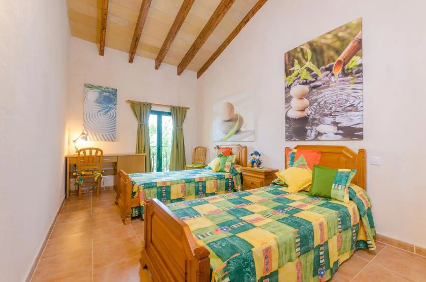 A bedroom with two beds and colorful patterned bedding.