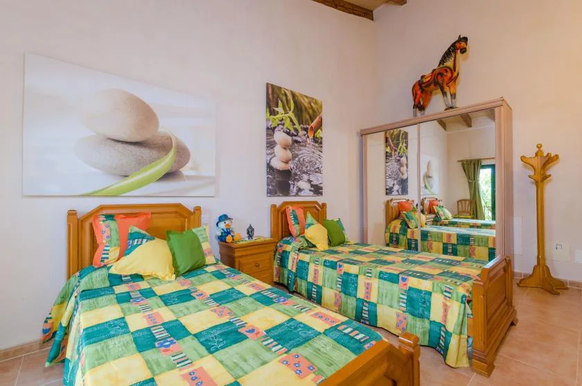 A bedroom with two beds covered in colorful patchwork bedding.