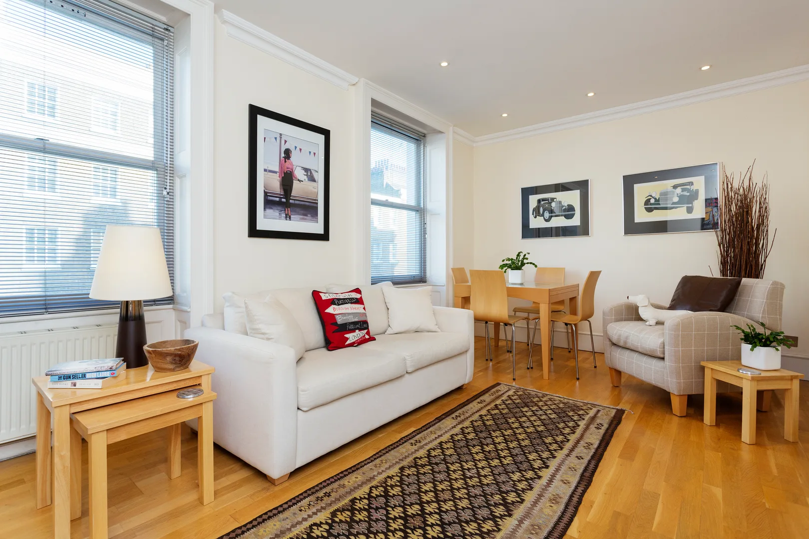 A bright living room with seating, a dining table, and large windows.