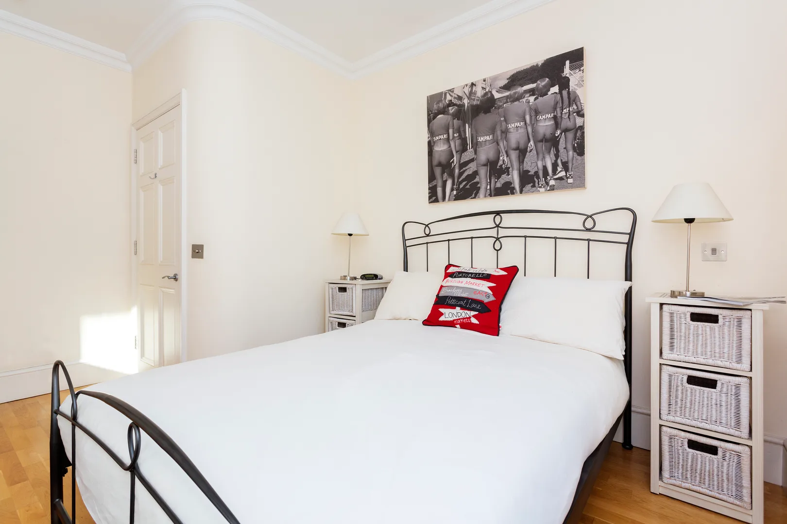A bright bedroom with a large bed and a black-and-white wall print.