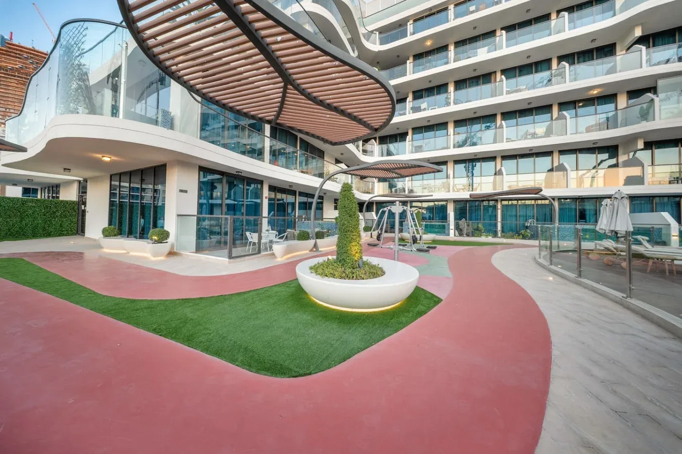 A landscaped outdoor courtyard with curved walkways in front of a modern building.