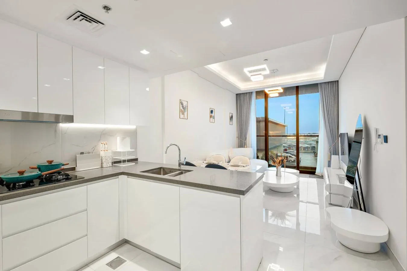 A bright open-plan kitchen and living area with a counter overlooking the seating space.