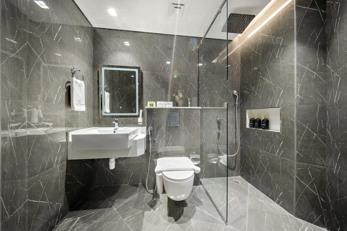 A modern bathroom with a sink, toilet, and glass shower.