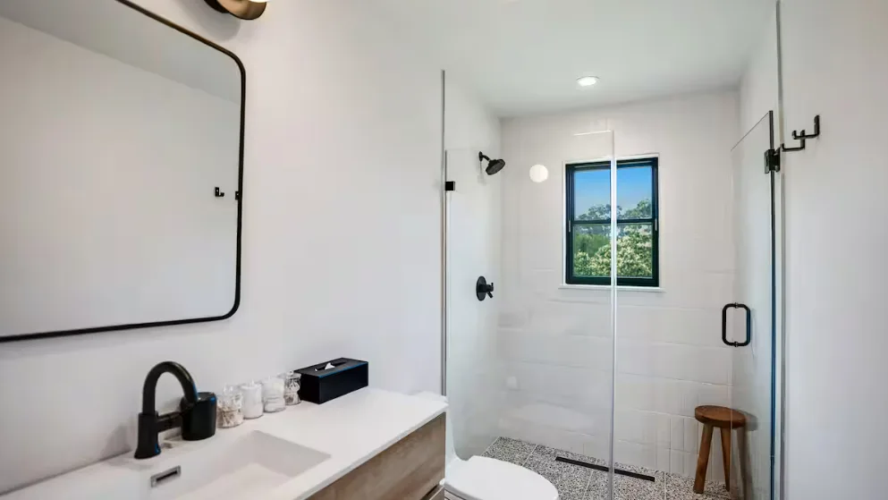 Un baño luminoso con lavabo y ducha con mampara de vidrio.