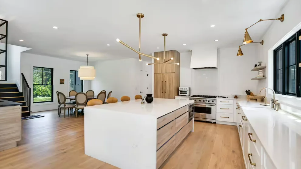 Una cocina luminosa con una isla grande y zona de comedor.
