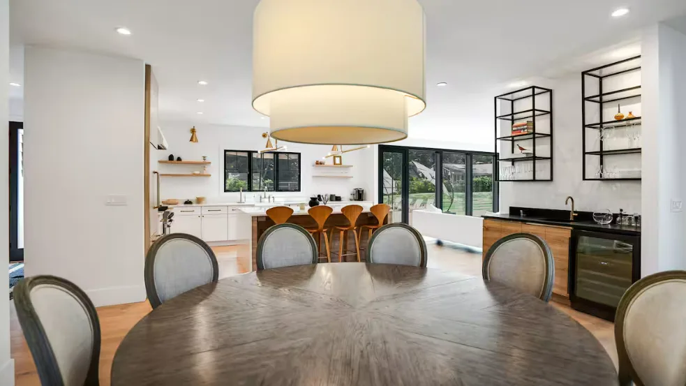 Una luminosa cocina abierta al comedor, con una mesa grande e isla.
