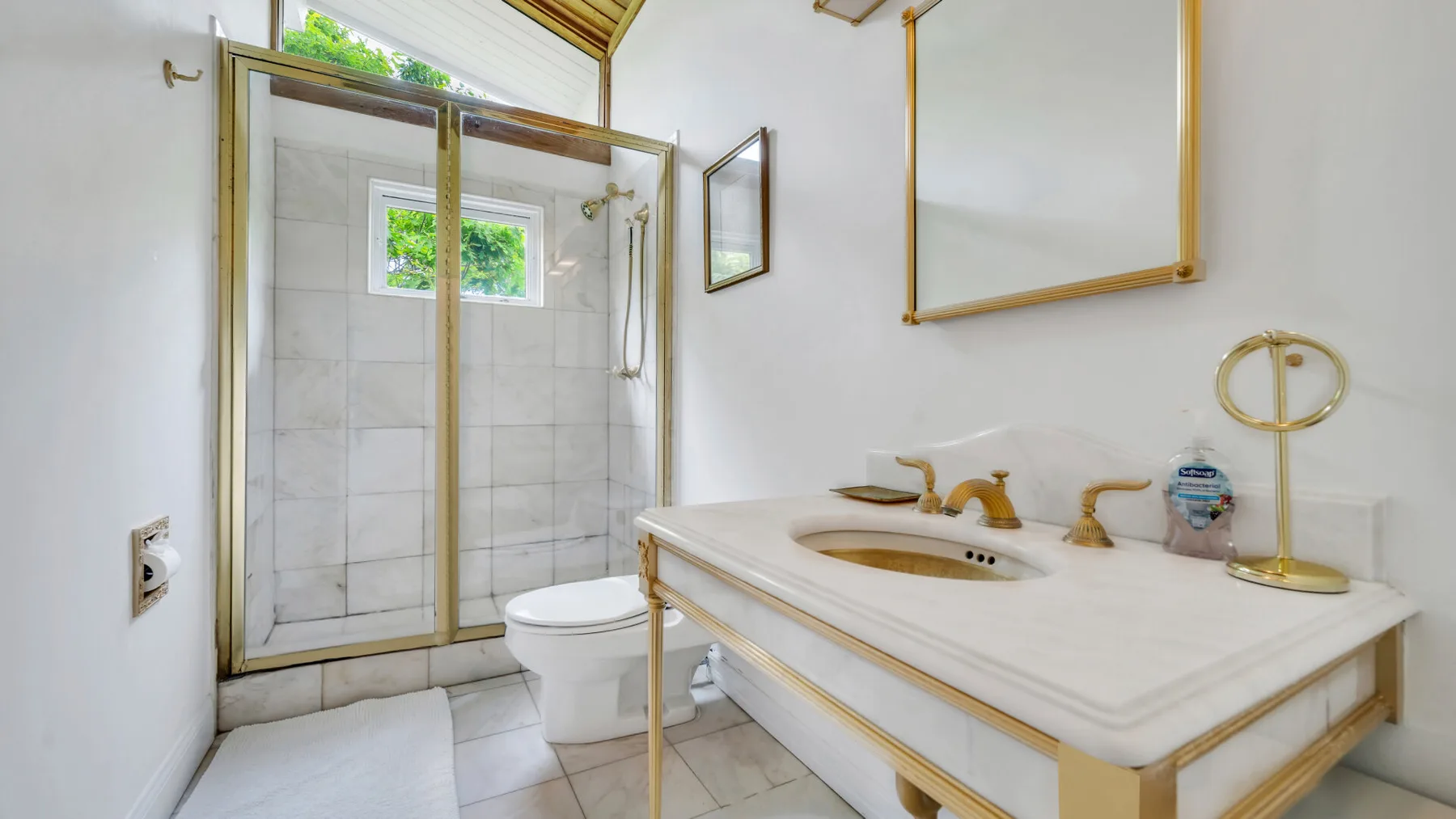 Un baño con ducha de vidrio, inodoro y lavabo.