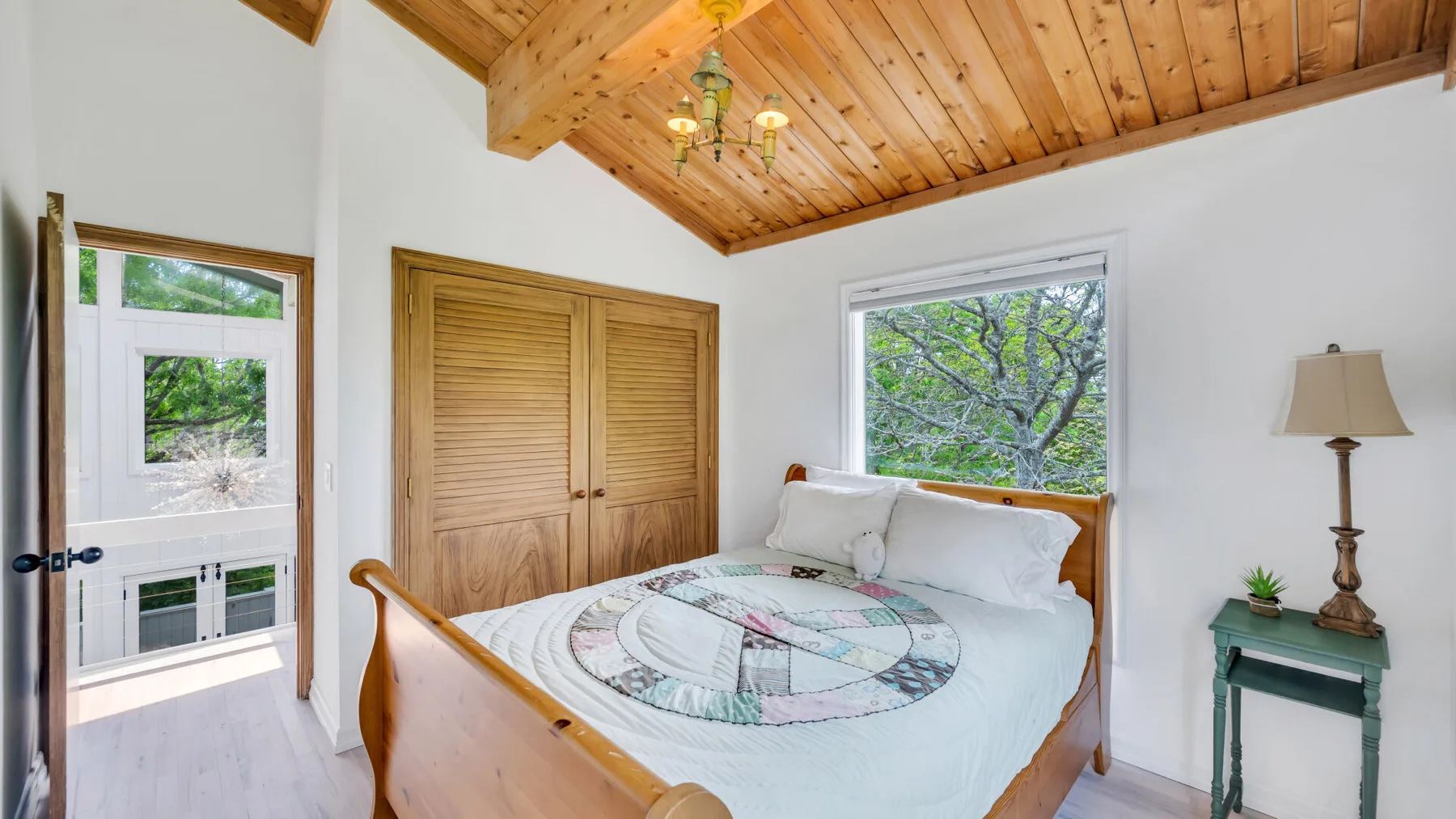 Un dormitorio con una cama, armarios de madera y techo revestido de madera.