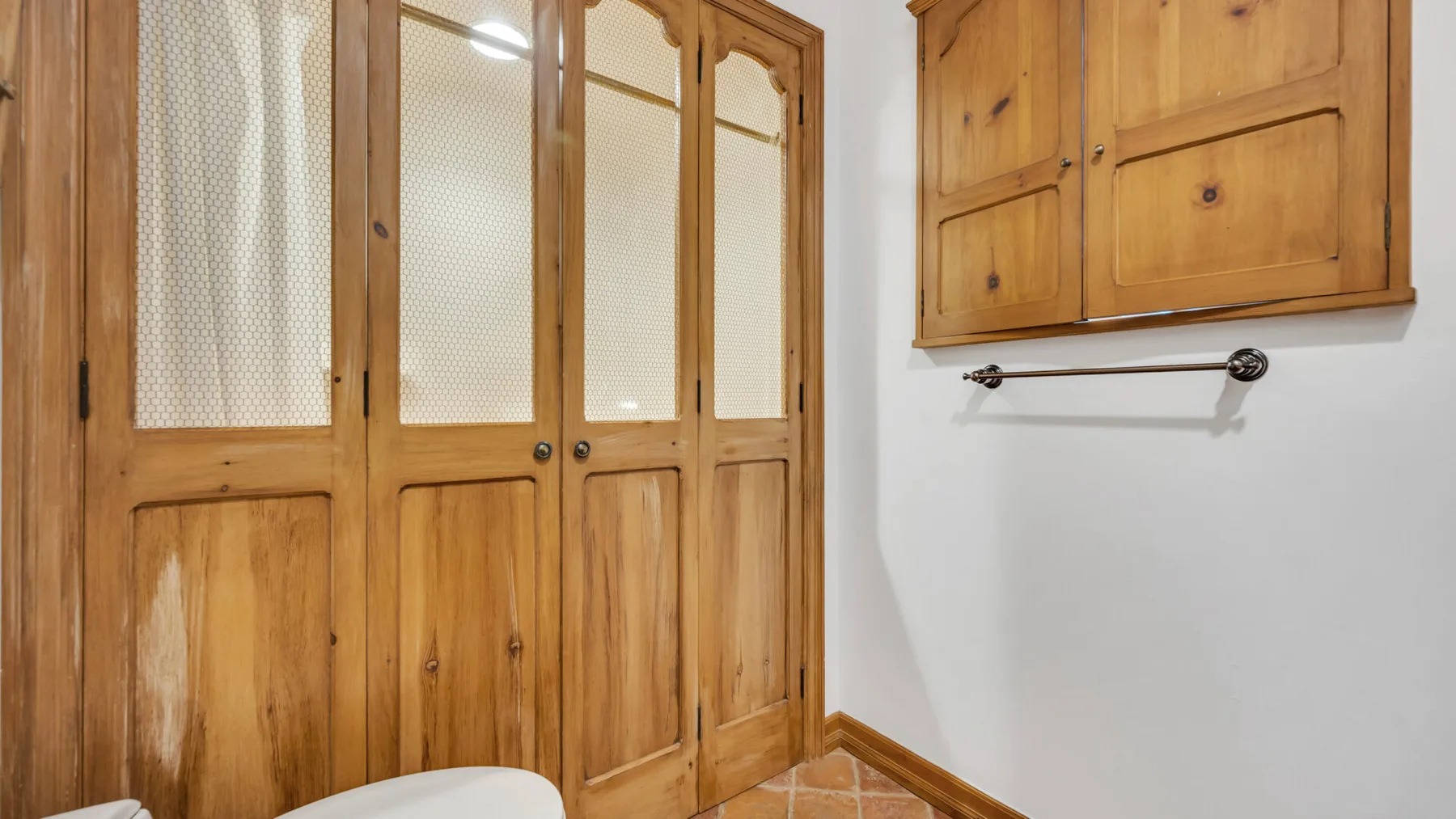 Una esquina de una habitación con armarios de madera y un ropero empotrado.