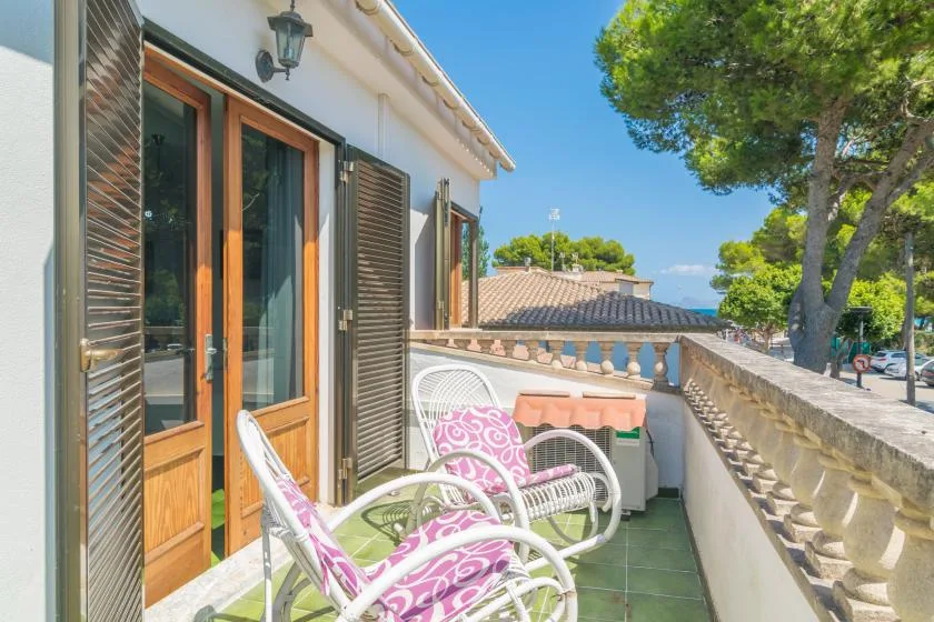 Una terraza soleada con asientos y una balaustrada de piedra.