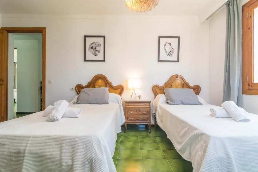 Un dormitorio con dos camas, mesillas de noche y cuadros en la pared.
