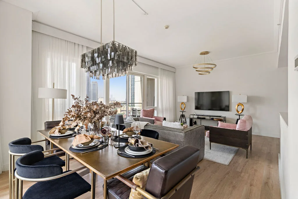 A bright living and dining area features a set dining table beside the seating area.