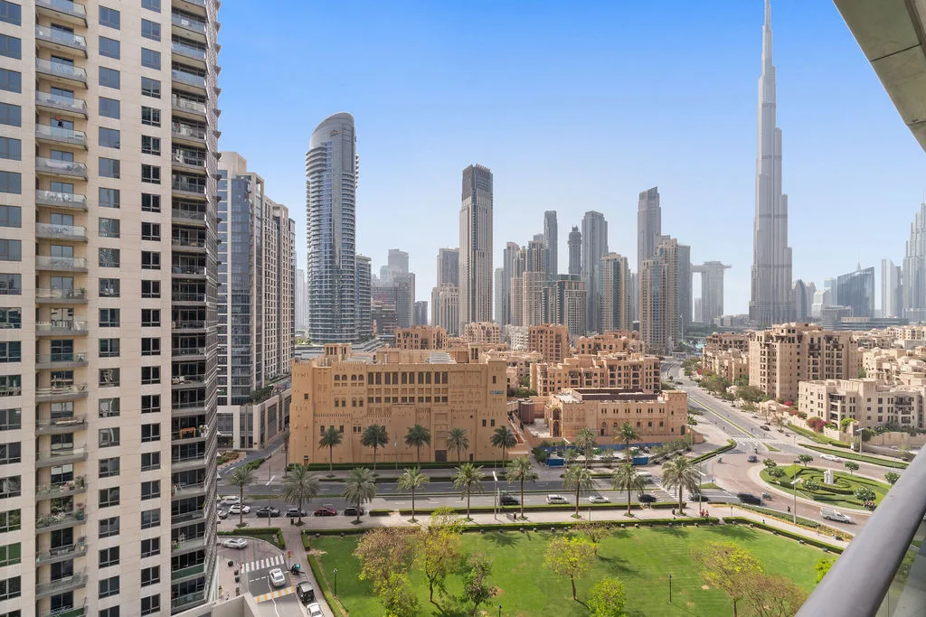 City skyline with a very tall tower rising above surrounding buildings.
