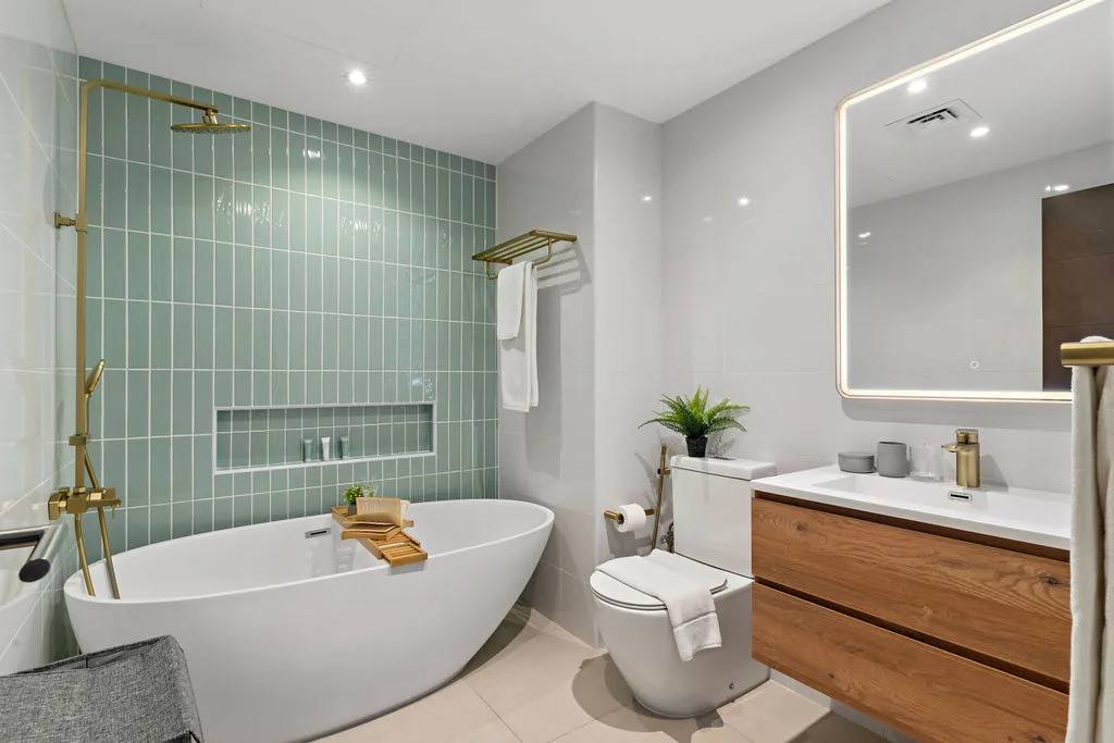 A bathroom with a freestanding bathtub, shower, toilet, and wood vanity.