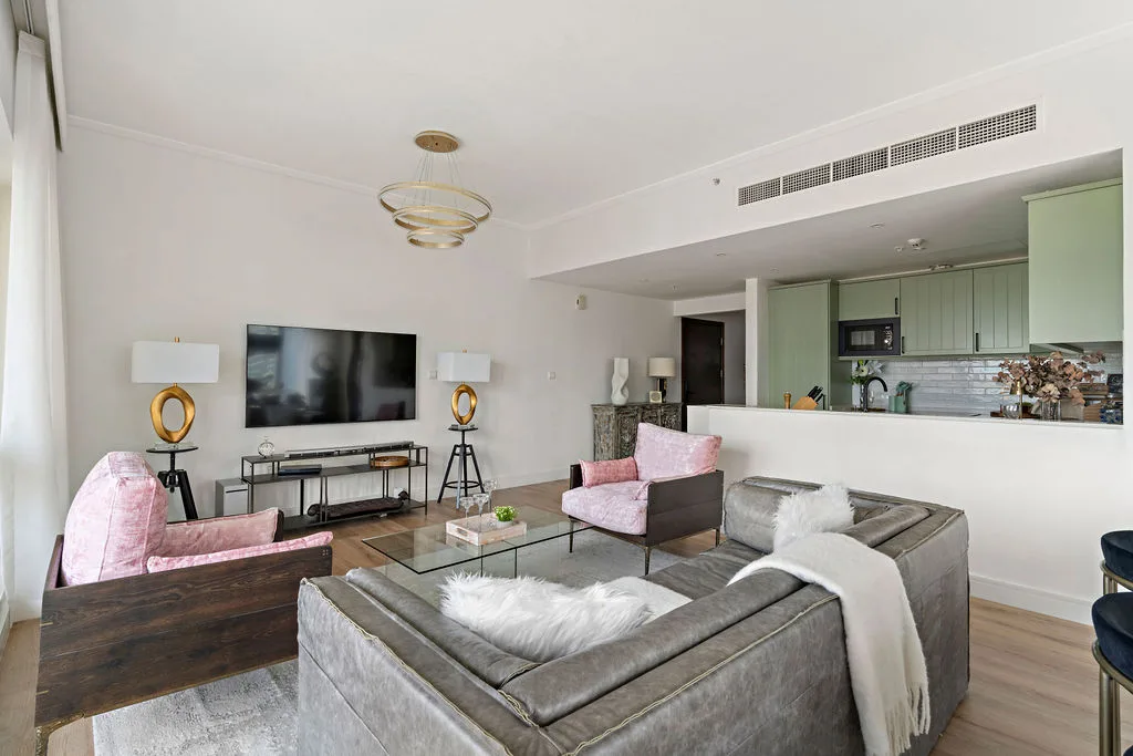 A bright living room with seating arranged around a glass coffee table.