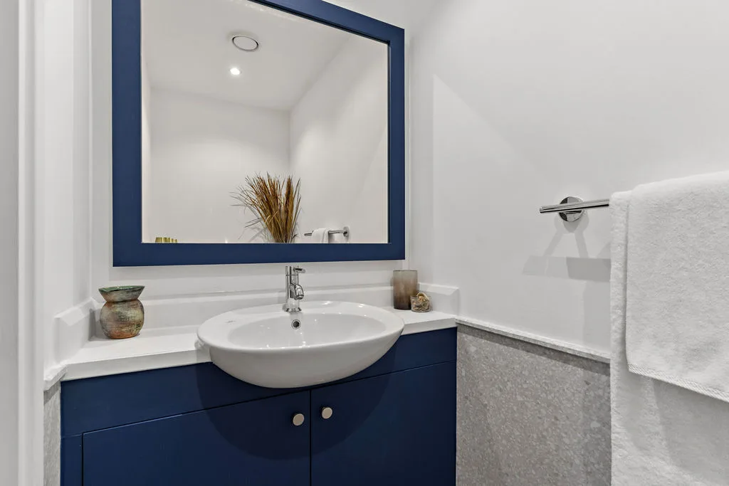 A bathroom vanity with a sink, mirror, and towel bar.