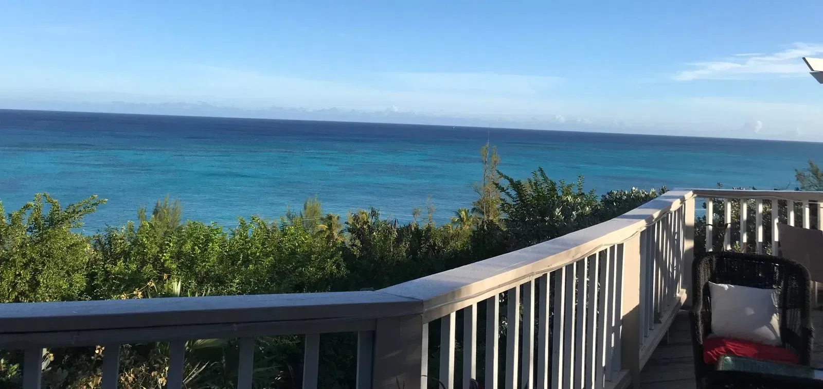 Vista del océano y los árboles desde una terraza