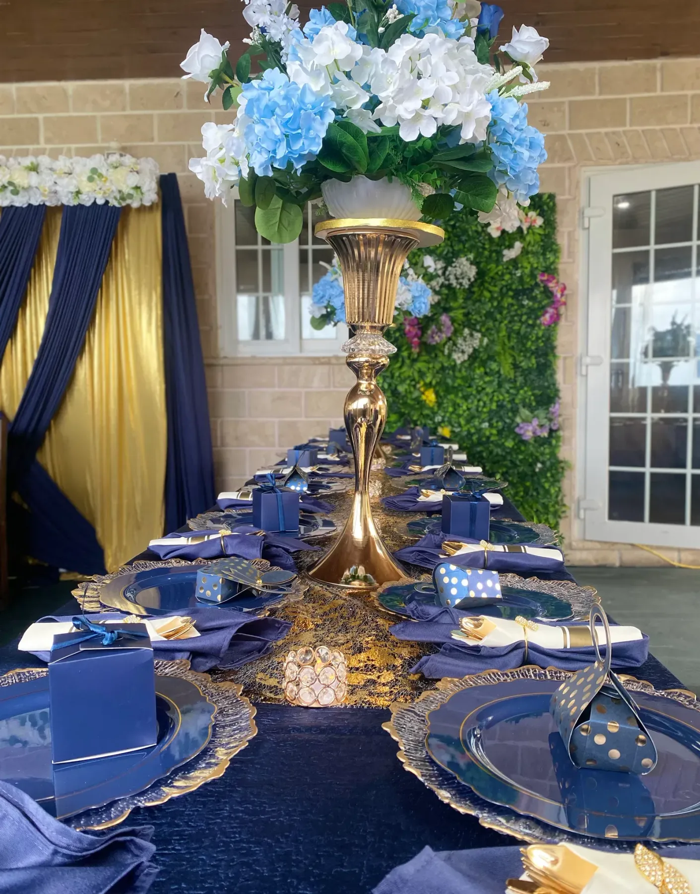 Mesa de banquete preparada con servilletas azul marino y un centro de mesa floral
