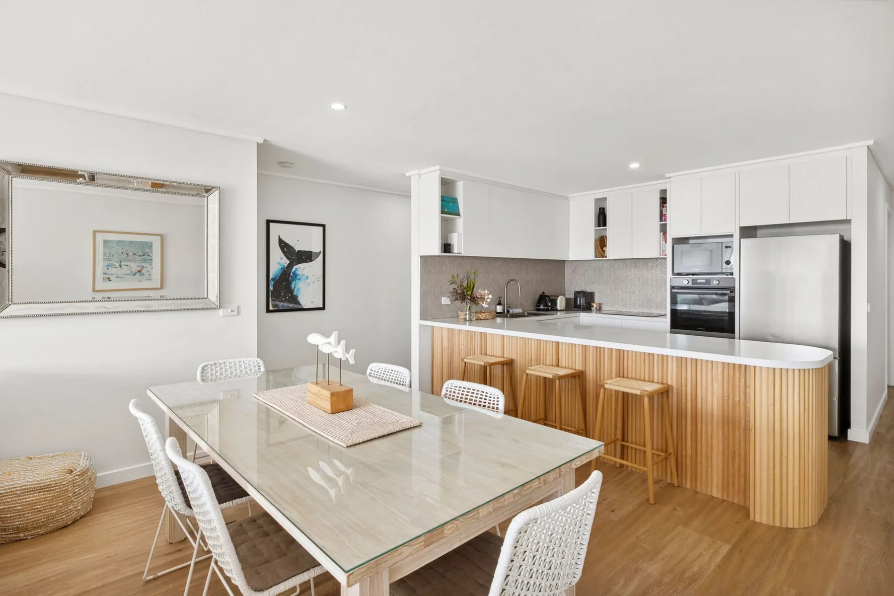 An open-plan kitchen and dining area with a long island and dining table.