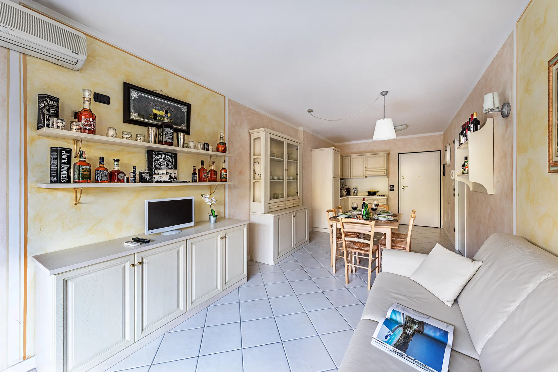 Una luminosa sala de estar y comedor con un sofá blanco y una mesa.