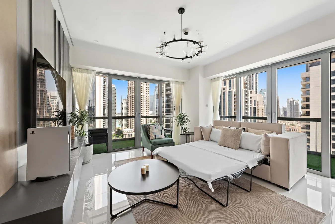 A bright living room with large windows, seating, and a round coffee table.