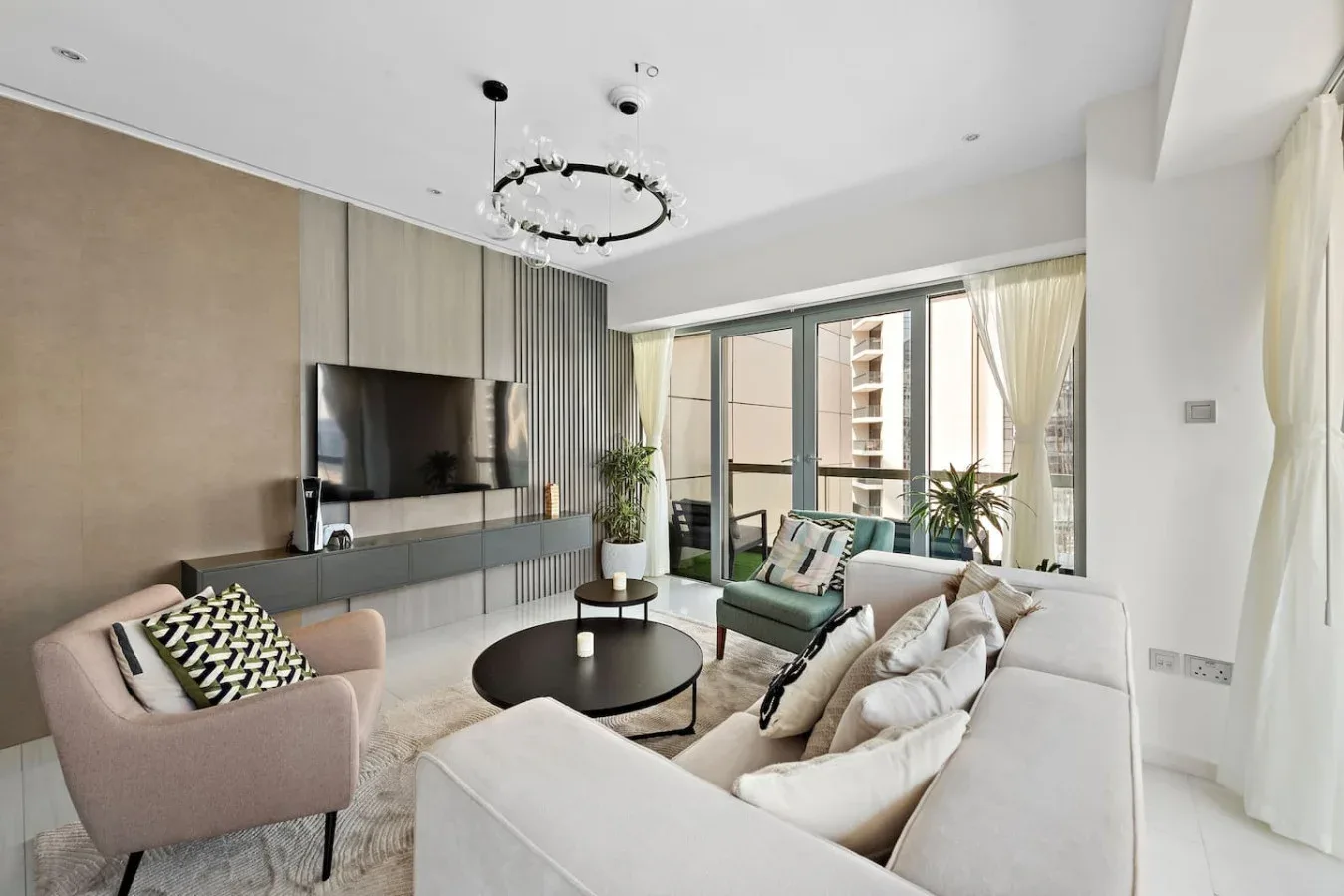 A bright living room with seating arranged around a round coffee table.