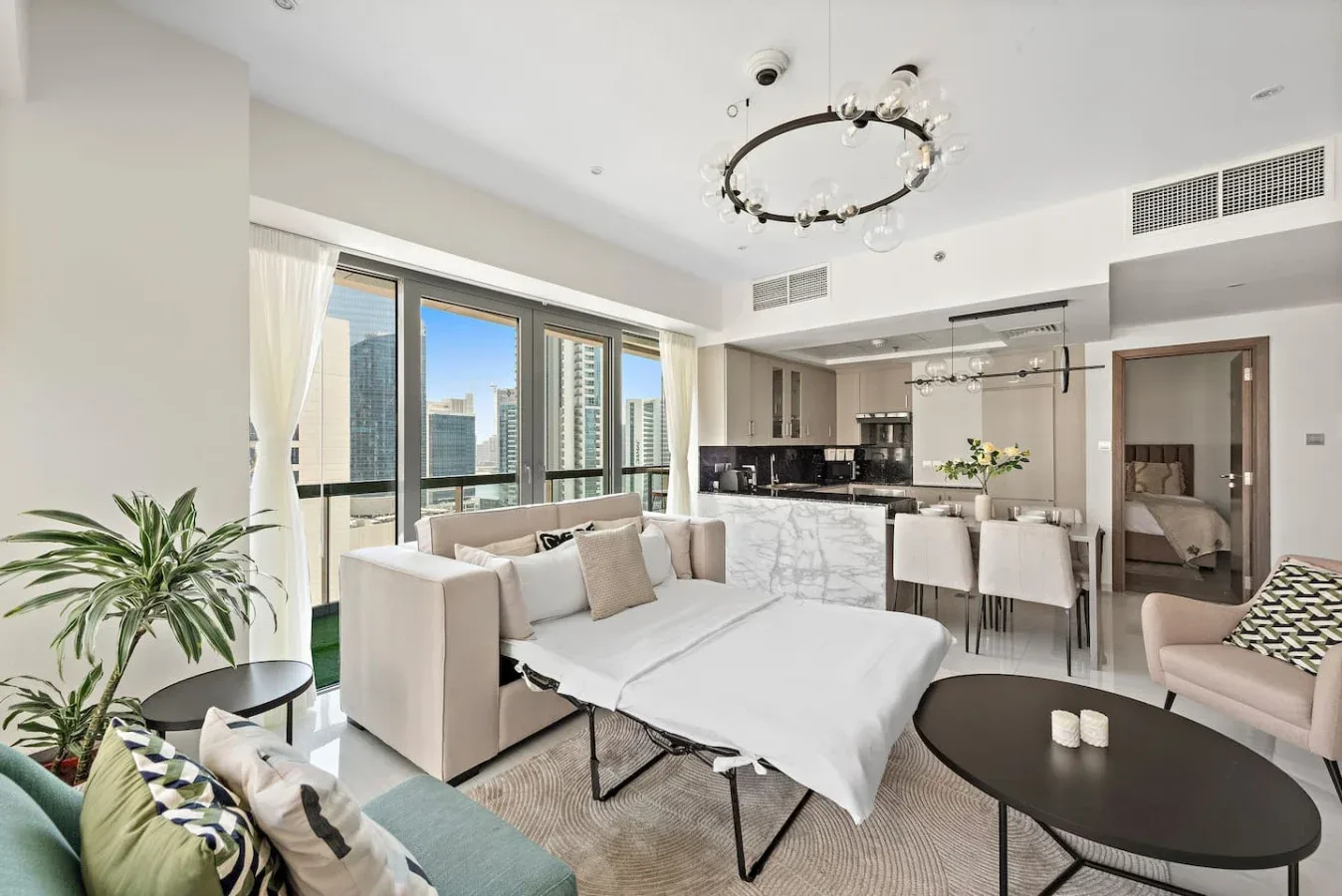 A bright open-plan living and dining area with a kitchen and large windows.