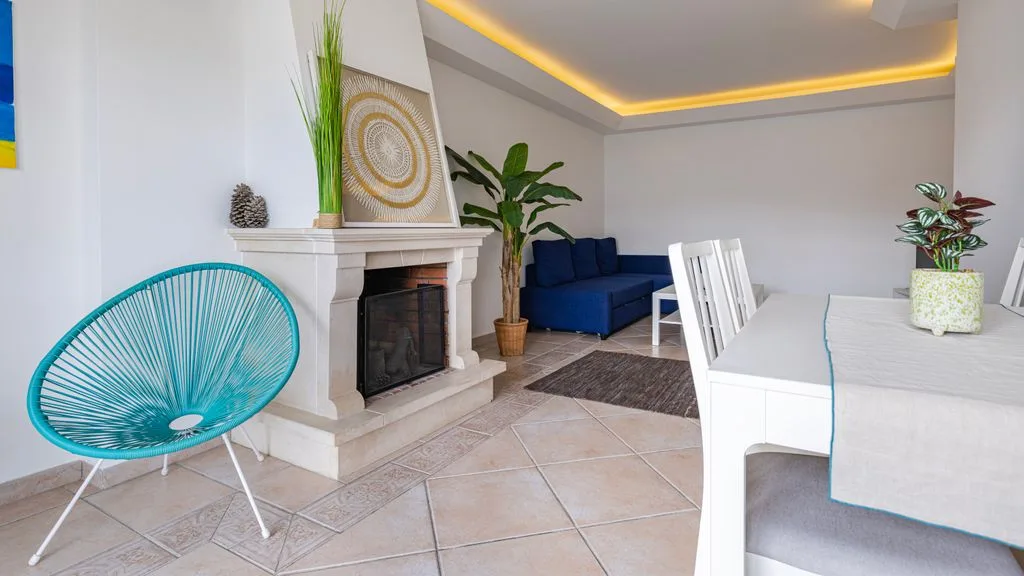 Una luminosa sala de estar y comedor con asientos azules y una chimenea.