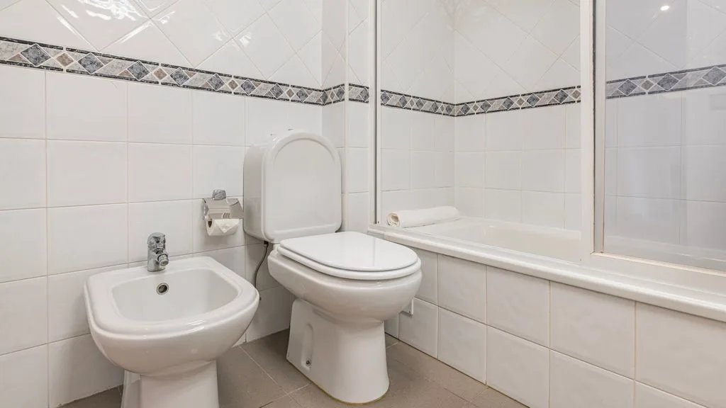 Un baño con inodoro, bidé y bañera.