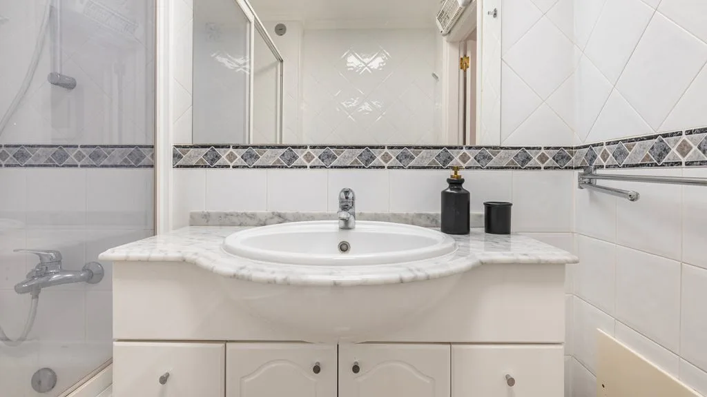 Un baño alicatado con lavabo y ducha.