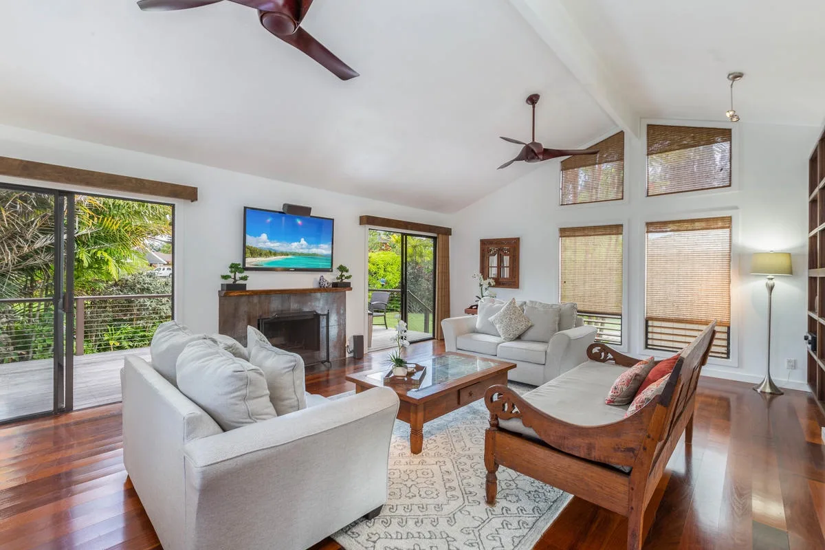 A bright living room with seating arranged around a fireplace and coffee table.