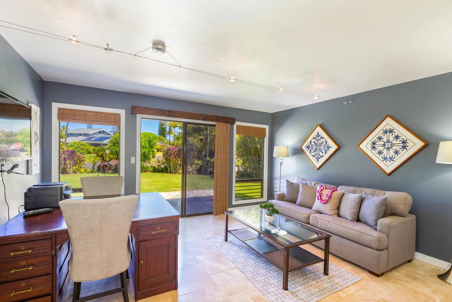 A living room with seating and a glass door opening onto a garden.