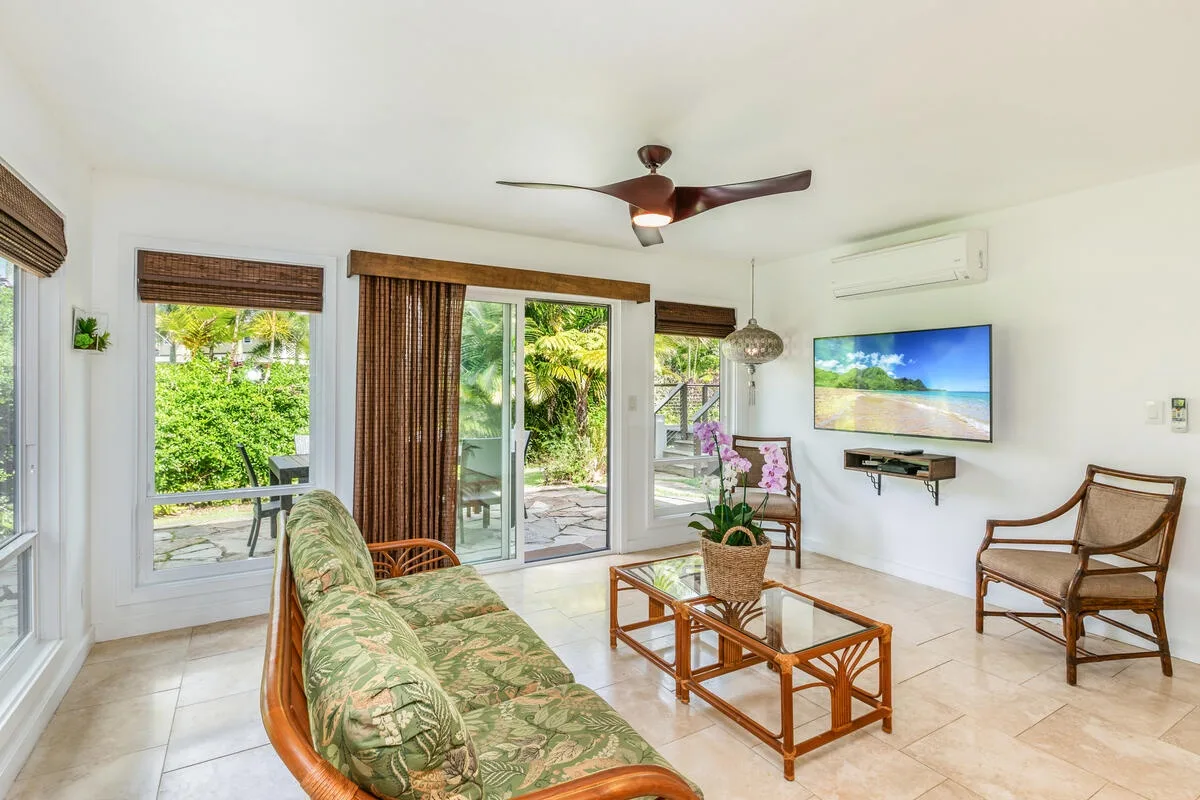 A bright living room with sliding glass doors opening onto a garden.