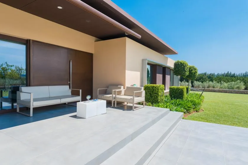 A modern patio with outdoor seating and a green lawn.