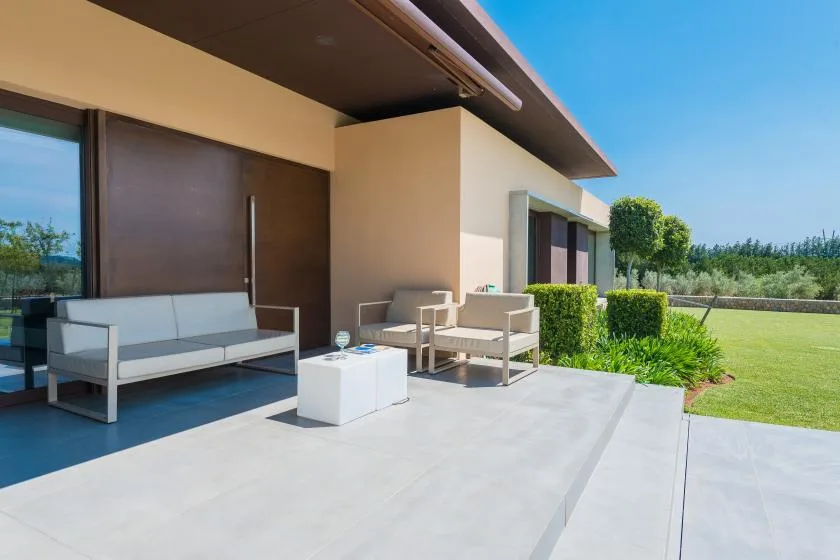 An outdoor patio with seating and a small table beside the house.