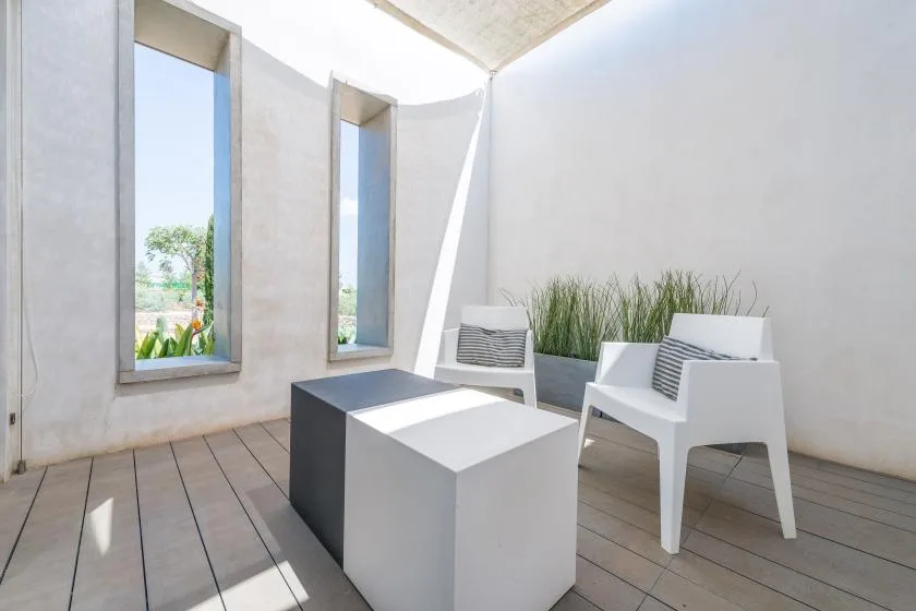 A bright outdoor seating area with modern chairs and a low table.