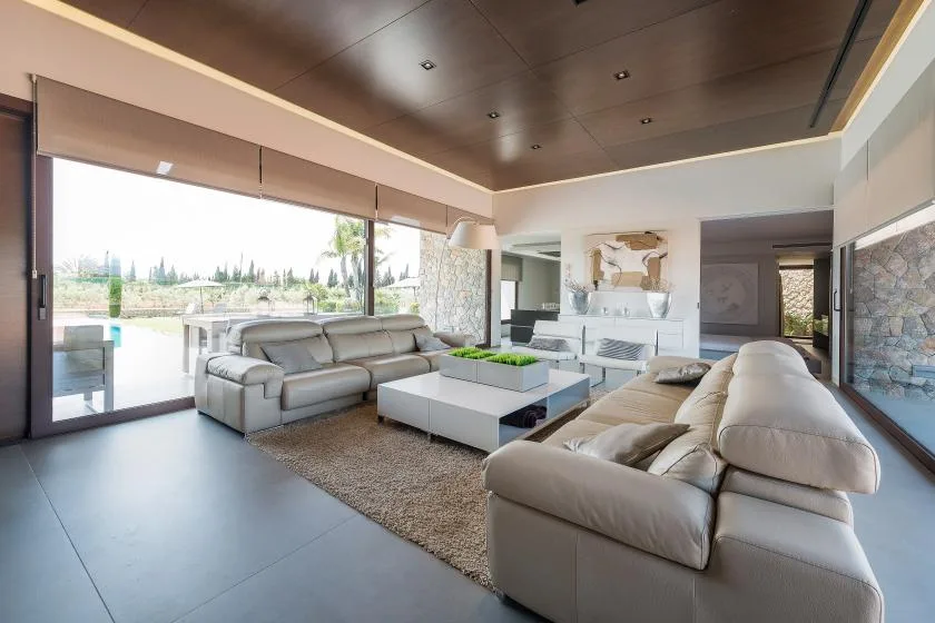 A modern living room with light-colored seating around a coffee table.