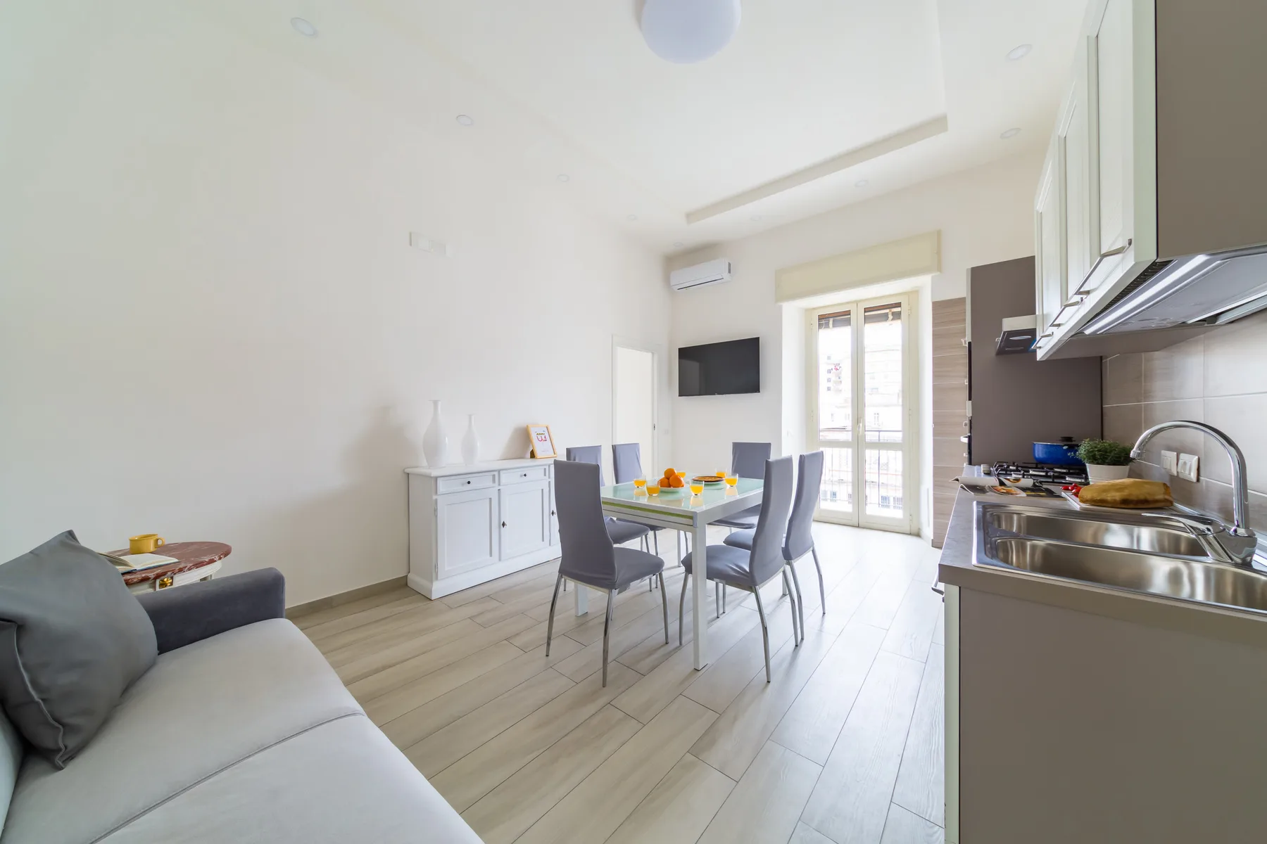A bright open-plan living and dining area with a kitchen along one side.