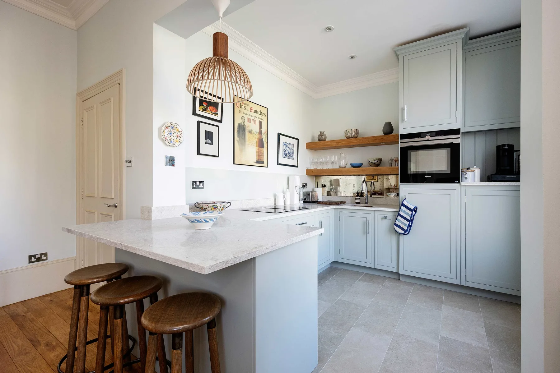 A bright kitchen with pale cabinets and a large island with seating.