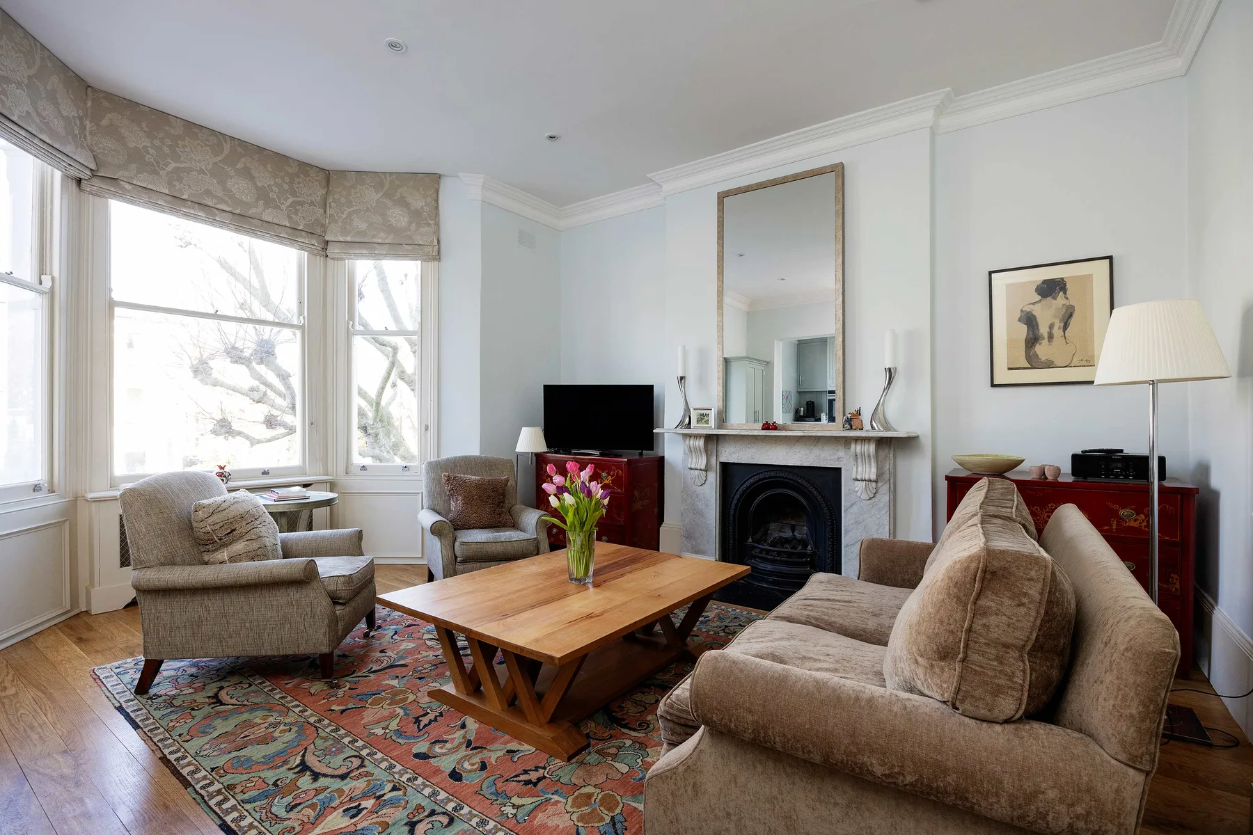 A bright living room with seating, a coffee table, and a fireplace.