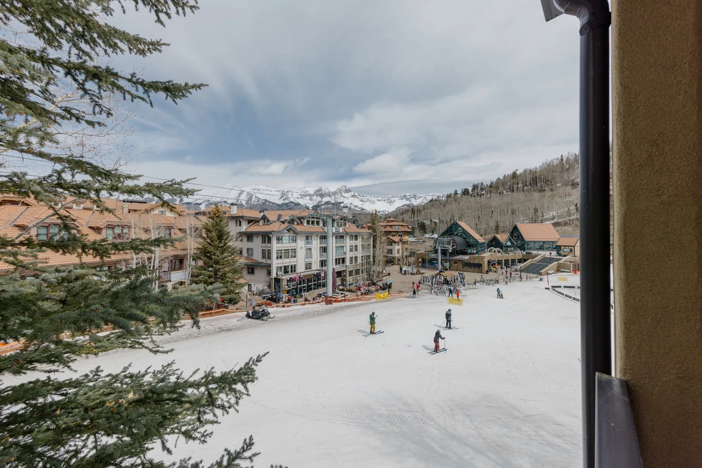 A snowy mountain resort is visible beyond an open ski area.
