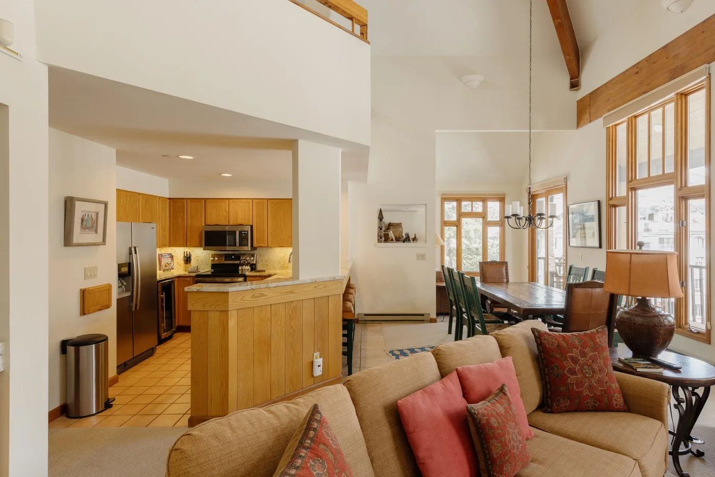 A bright open-plan living and dining area with a kitchen and large windows.